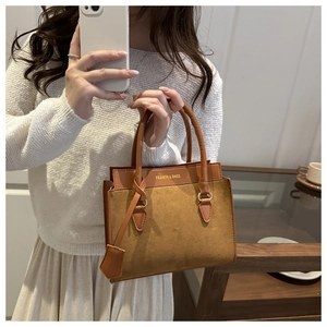 Détail du sac à main en daim caramel et cuir lisse avec lettrage mode sophistiqué