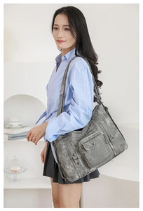 Close-up of vintage grey tote bag with rustic texture and functional zipper pockets