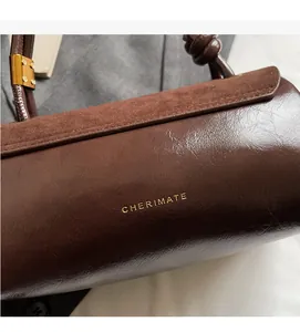Detail of CHERIMATE dark brown suede and leather handbag with gold metal hardware