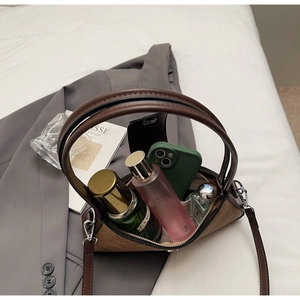 Top view of brown suede bag showing interior capacity with cosmetics and smartphone