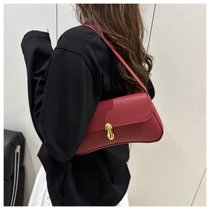 Détail du sac rouge en cuir grainé avec fermoir barre dorée et rabat pour femme élégante