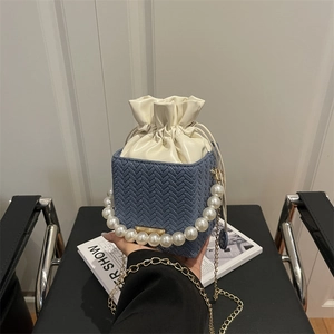 Blue woven leather crossbody bag with pearl handle, chain strap and drawstring lining