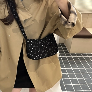 Black nylon crescent crossbody bag with heart bow patterns and wide printed shoulder strap