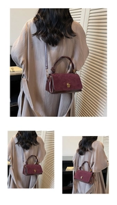 Close-up of vintage burgundy suede satchel with golden clasp and leather handle