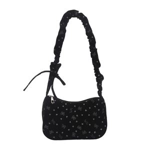 Black pleated shoulder bag with bow prints and heart patterns on textured fabric