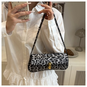Detailed view of grey leopard print baguette bag with gold buckle and textured shoulder strap