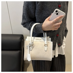 Détail du petit sac carré crème avec logo Fashion & Bags et finitions de couture élégantes