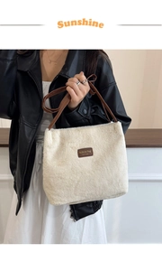 Détail d'un sac cabas en fausse fourrure blanche avec étiquette en cuir marron