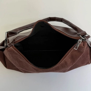 Top view of large brown shoulder bag with velvet patchwork, zip closure, and black lining