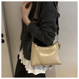 Detail of cream white leather baguette bag with ethnic style jacquard wide shoulder strap