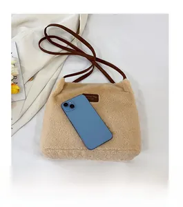 Gros plan d'un sac cabas en peluche beige avec texture polaire douce et logo en cuir
