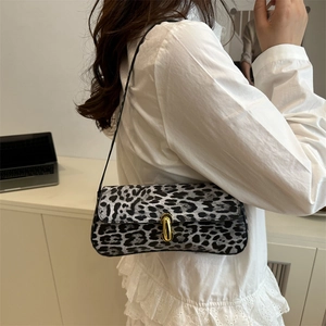 Trendy leopard print underarm bag with gold oval buckle shown on a model