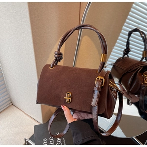 Detail of suede and leather crossbody bag with golden twist lock and rope knot handle
