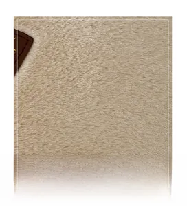 Gros plan sur la texture en fausse fourrure beige et détail en cuir monogrammé