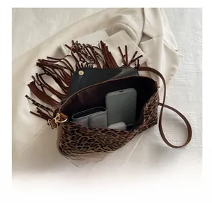 Internal view showing capacity of leopard print tassel bag for phone and wallet