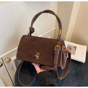 Detail of vintage brown suede crossbody bag with gold metal twist lock and knotted handle