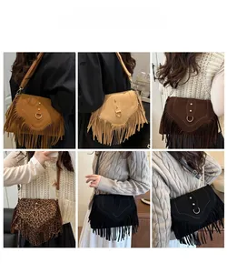 Detail view of bohemian crossbody bags with long tassels and metallic ring accents