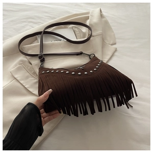 Dettaglio borsa a tracolla marrone vintage con borchie argentate e nappe lunghe
