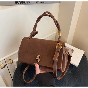Detail showing dark brown suede and leather patchwork bag with retro metal twist lock