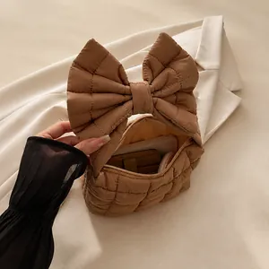 Internal view of brown quilted bag showing storage for phone and cosmetics