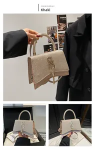 Macro shot of khaki luxury handbag featuring shimmering rhinestones and golden S clasp
