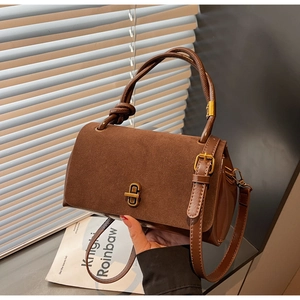 Detail of dark brown suede and leather splicing with a gold square rotary lock buckle