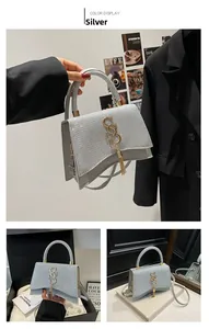 Detailed view of a silver sequined handbag featuring a metallic buckle and curved base