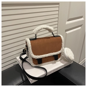 Detail of brown suede crossbody bag with white faux shearling trim and coin purse