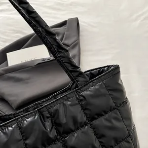 Detail showing high-quality stitching and quilted texture of the black padded tote bag