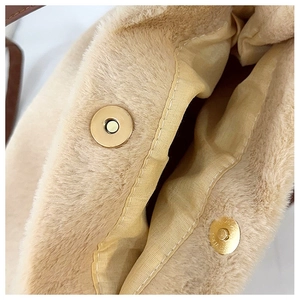 Détail du sac en peluche avec boucle magnétique dorée et doublure en satin lisse