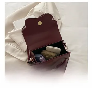 Dettaglio dell'interno di una borsa bordeaux che mostra spazio e chiusura in metallo