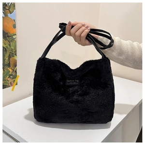 Gros plan du sac fourre-tout en peluche noire avec patch en cuir et longue bandoulière