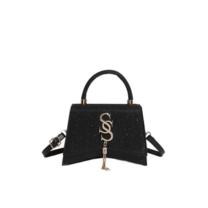 Elegant hourglass shoulder bag in black leather with a glitter flap and gold tassel