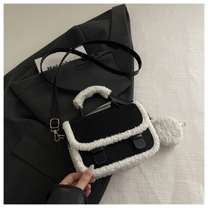 Detail of crossbody bag featuring black fabric and contrast white shearling trim with coin purse