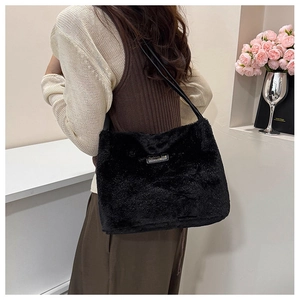 Détail du sac à épaule en peluche noire avec étiquette Fashion Bag porté par un modèle