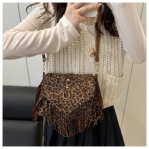Dettaglio borsa a sella leopardata con lunghe nappe e borchie in metallo dorato