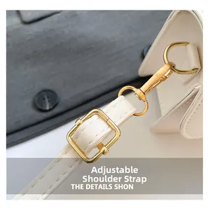Detail of adjustable shoulder strap with golden metal hardware on a cream leather handbag