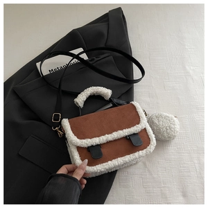 Detail of suede crossbody bag with faux shearling trim and round plush coin purse charm