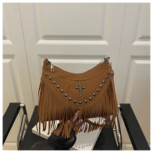 Dettaglio borsa scamosciata marrone con nappe, borchie vintage e ciondolo croce argento