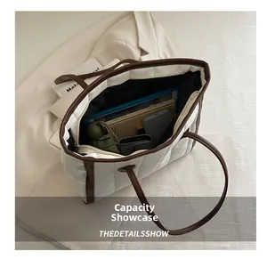 Detail of spacious interior capacity for padded tote bag showing books and umbrella