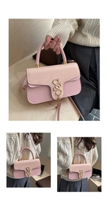 Detail van roze crossbodytas met slangenstructuur en gouden S-vormige metalen gesp