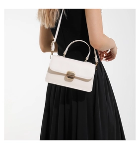 Back view of model carrying a white leather square handbag over a black dress