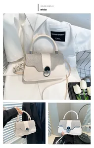 Close-up of cream white box bag featuring sparkling rhinestone flap and top handle