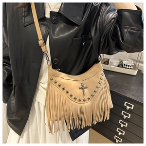 Dettaglio borsa a tracolla boho kaki con frange, borchie metalliche e ciondolo a croce