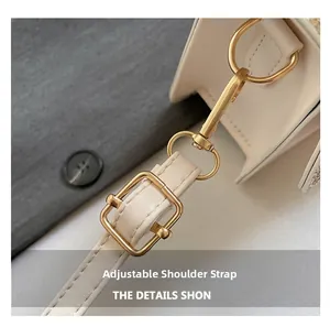 Détail de la bandoulière réglable avec boucles dorées sur le sac à main en cuir crème