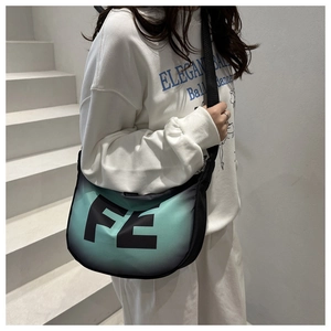 Détail du sac croissant dégradé vert avec imprimé FE et bandoulière noire réglable