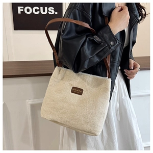 Détail d'un sac cabas en peluche blanc crème avec bandoulière en cuir marron