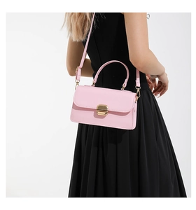 Detail view of pink minimalist crossbody bag with golden metal buckle and smooth leather