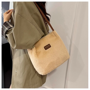 Détail du sac fourre-tout en peluche abricot avec étiquette en cuir et fines bandoulières