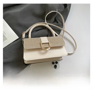 Close-up of cream leather handbag featuring contrast weave flap and gold U-shaped metal lock